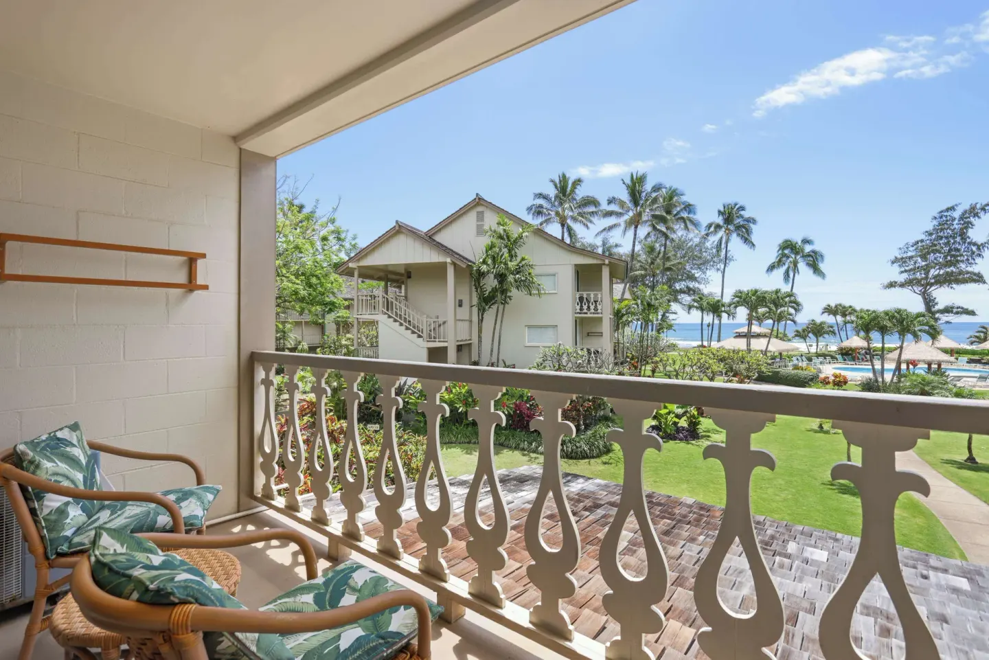 Balcony with chairs overlooking gardens and ocean at Aston Islander on the Beach.