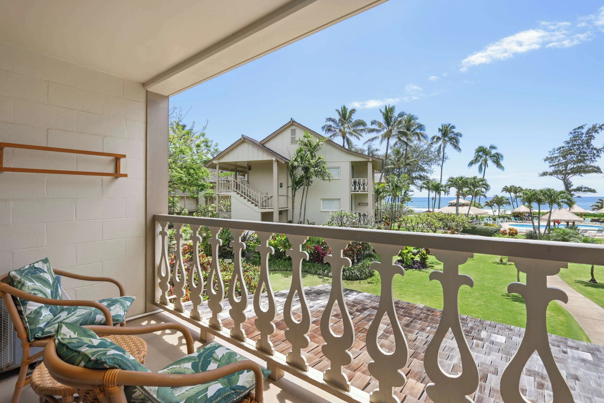 Balcony with chairs overlooking gardens and ocean at Aston Islander on the Beach.