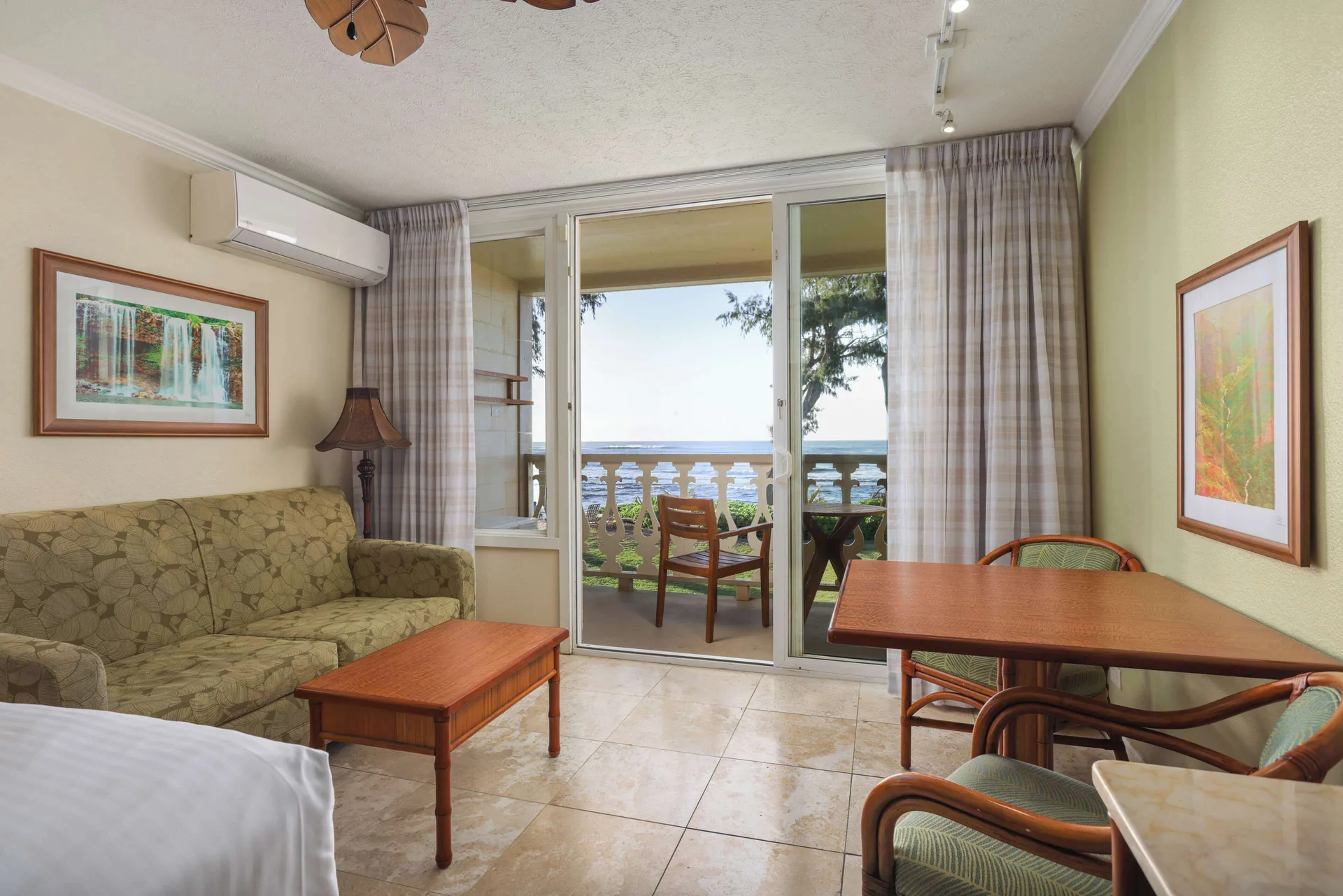 Guest room sitting area with ocean-facing balcony at Aston Islander on the Beach.