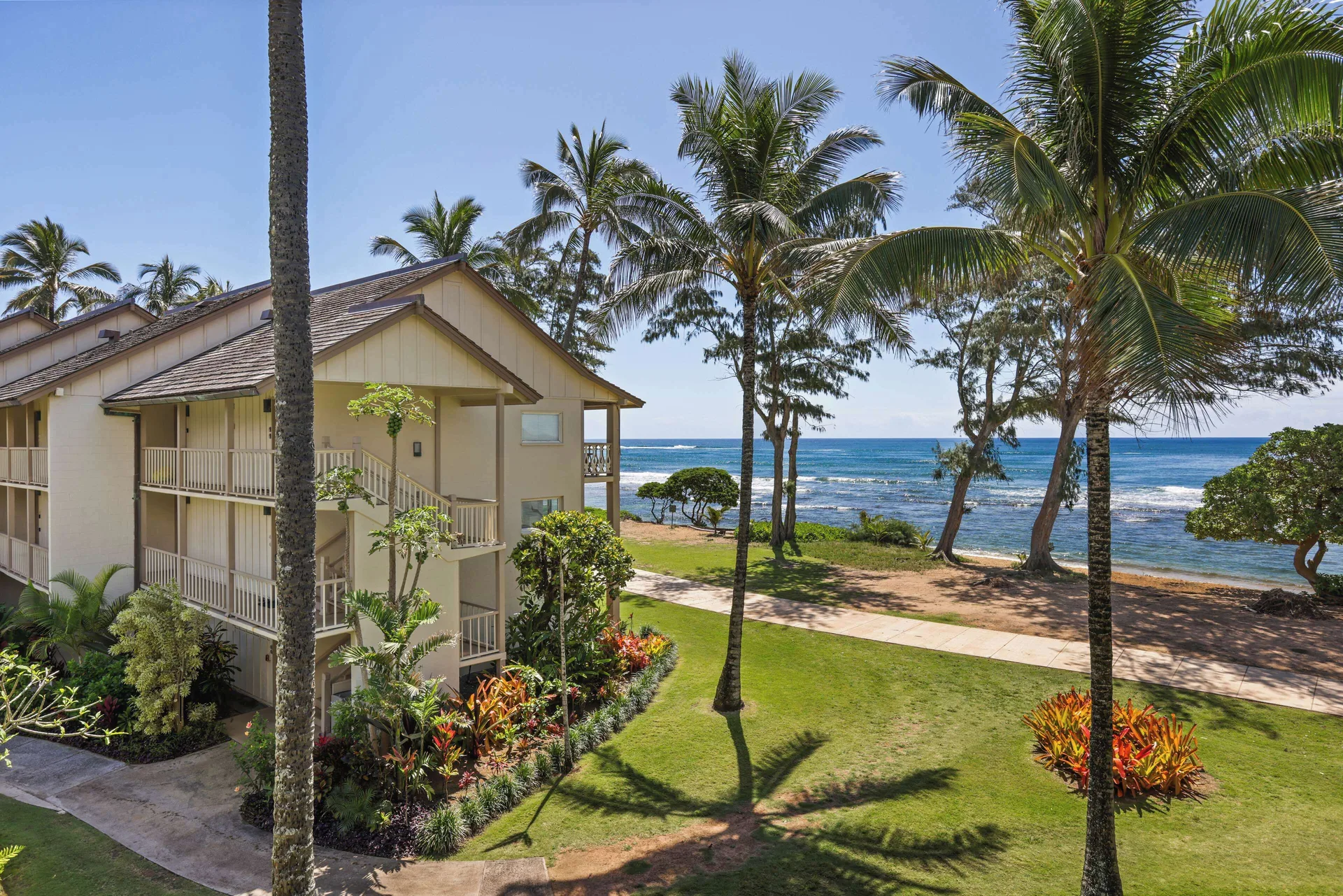 Oceanfront lawn, palms, and resort building at Aston Islander on the Beach.