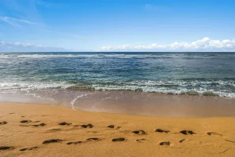 Footprints in sand by the ocean at Aston Islander on the Beach.