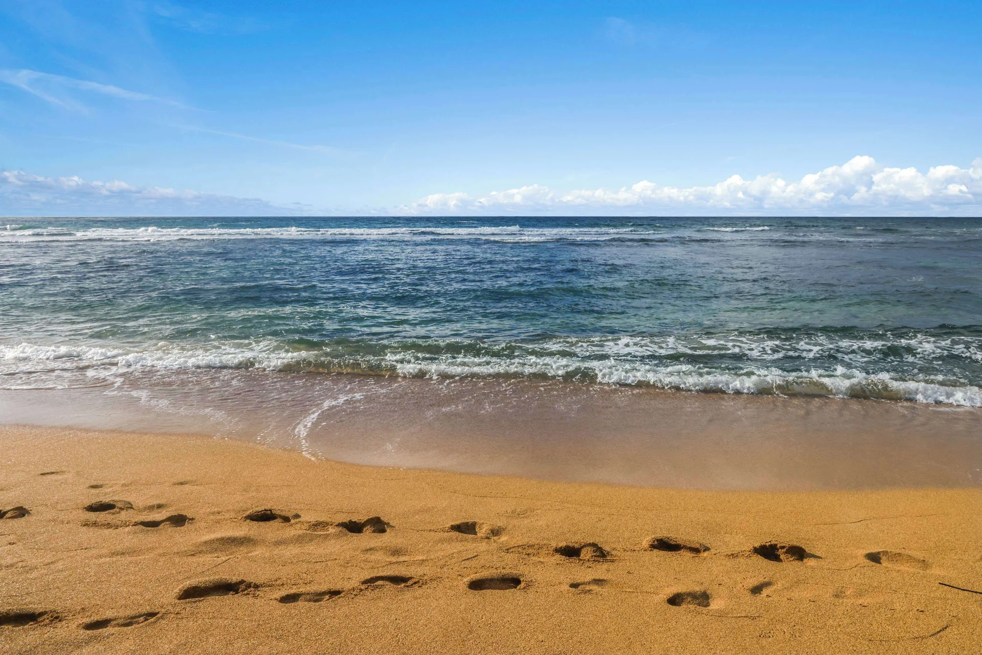 Footprints in sand by the ocean at Aston Islander on the Beach.