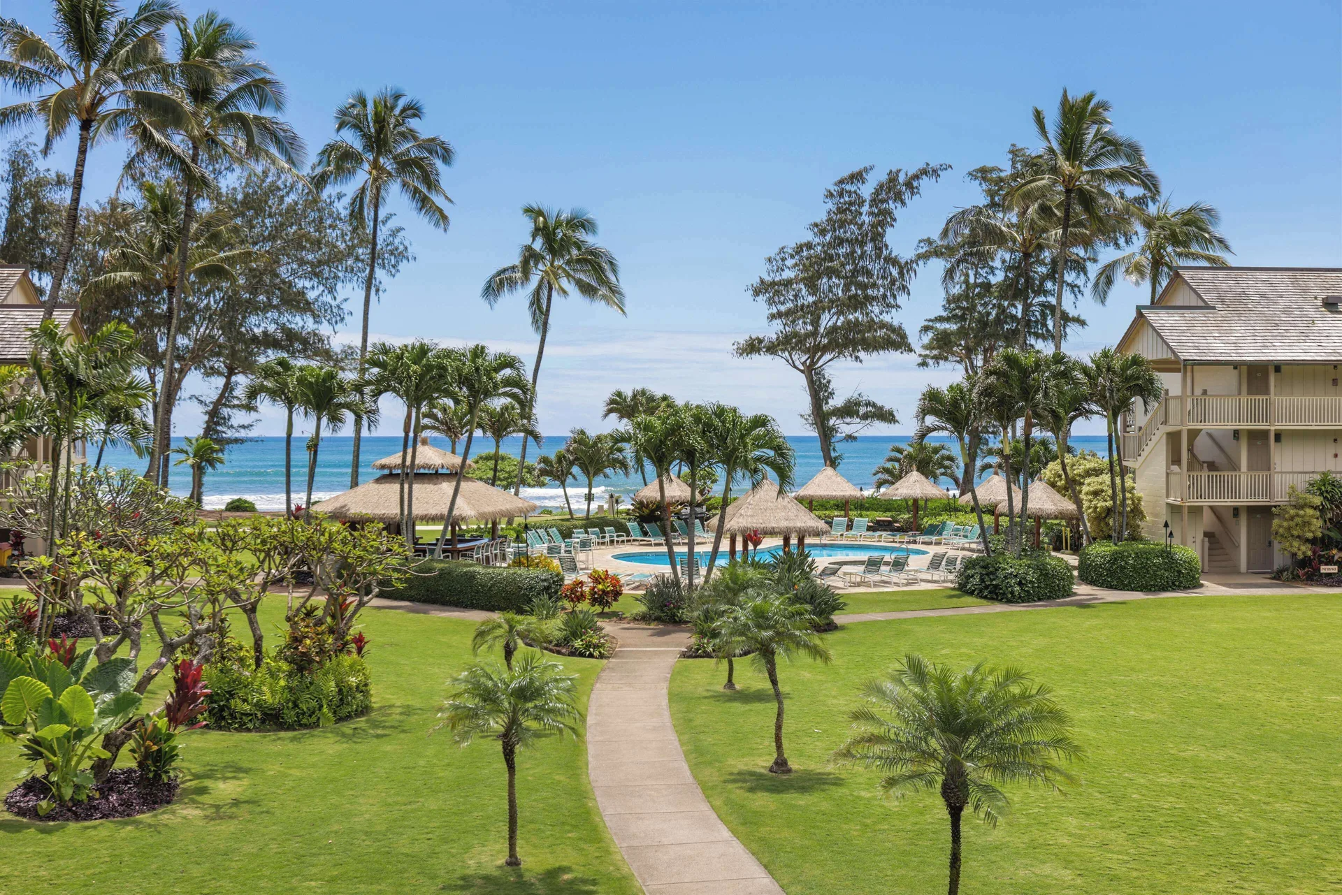 Ocean view over lawns, palms and the pool from the Panoramic Suite at Aston Islander on the Beach.