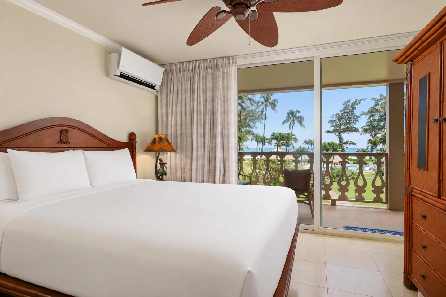 Panoramic Suite bedroom with king bed and balcony ocean view at Aston Islander on the Beach.