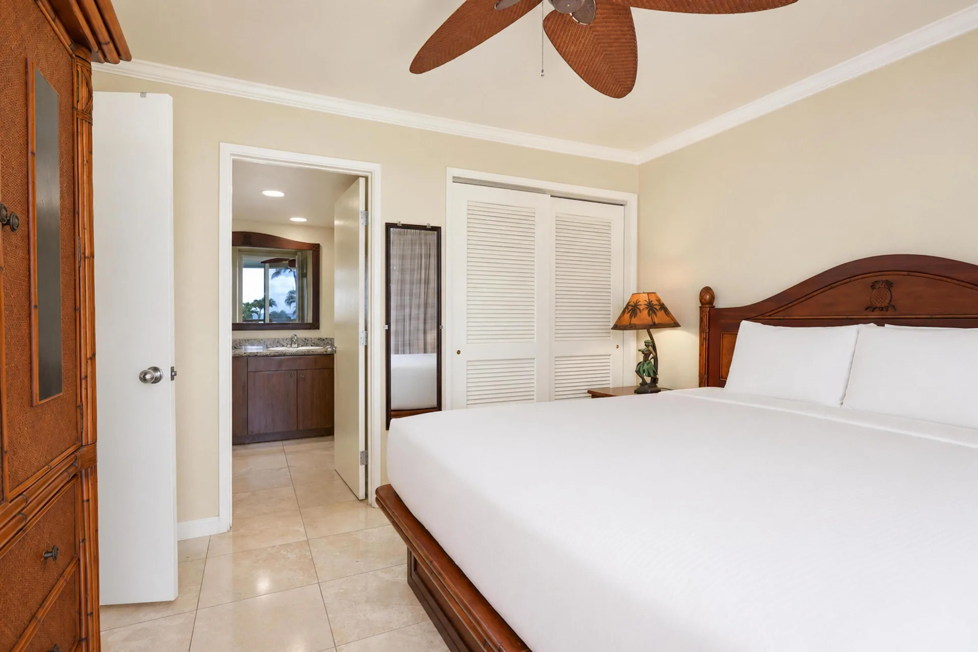 Panoramic Suite king bedroom with closet and bathroom doorway at Aston Islander on the Beach.