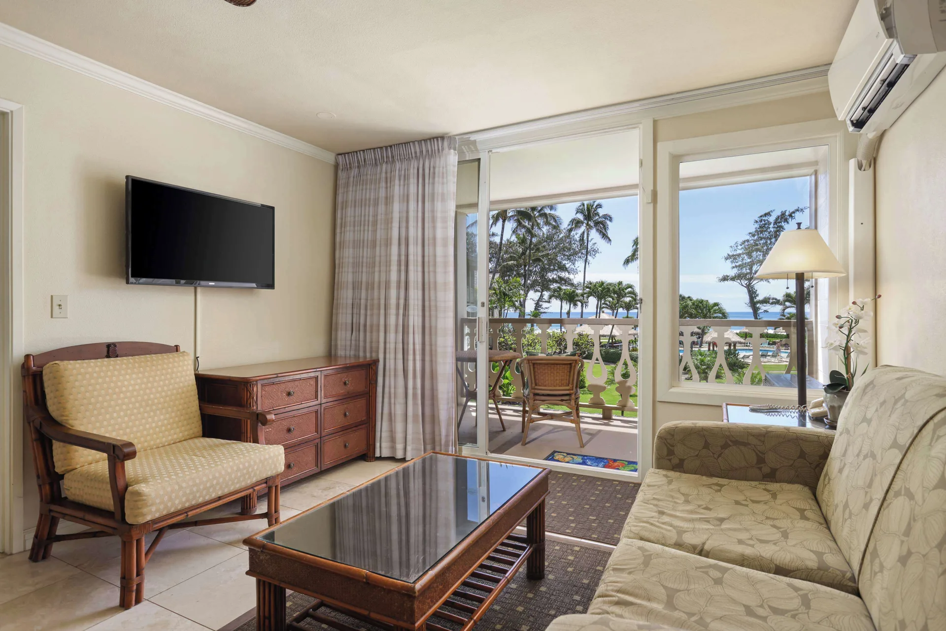 Panoramic Suite living room with balcony doors and ocean view at Aston Islander on the Beach.