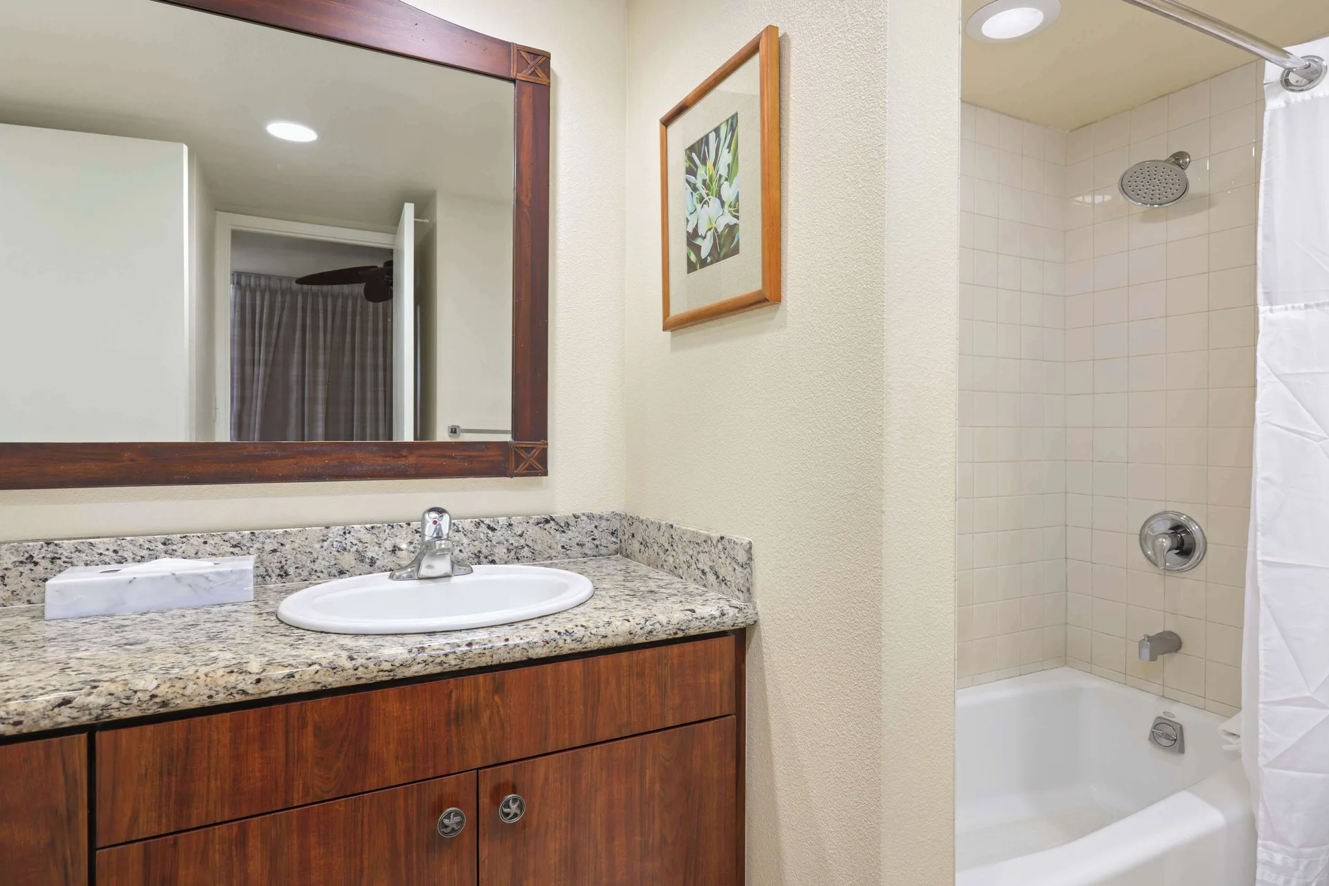 Garden View room bathroom with vanity and tub shower at Aston Islander on the Beach.