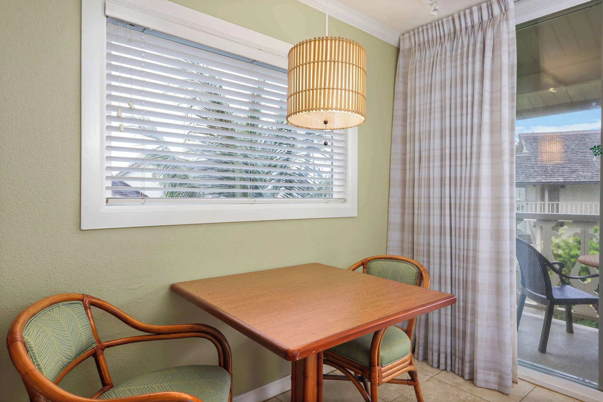 Garden View room dining table beside a balcony door at Aston Islander on the Beach.