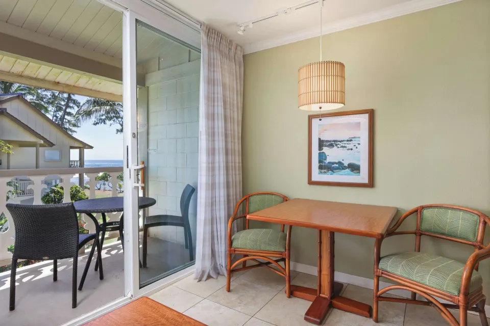 Ocean View room dining table beside balcony with partial ocean view at Aston Islander on the Beach.