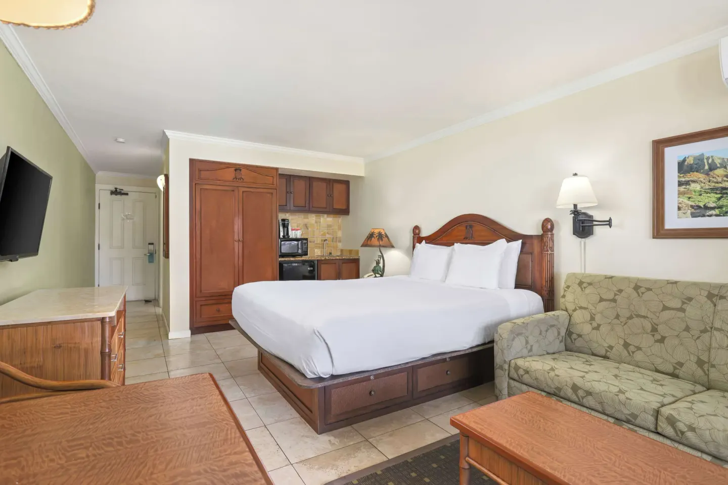 Ocean View room with king bed, sofa, kitchenette, and TV at Aston Islander on the Beach.