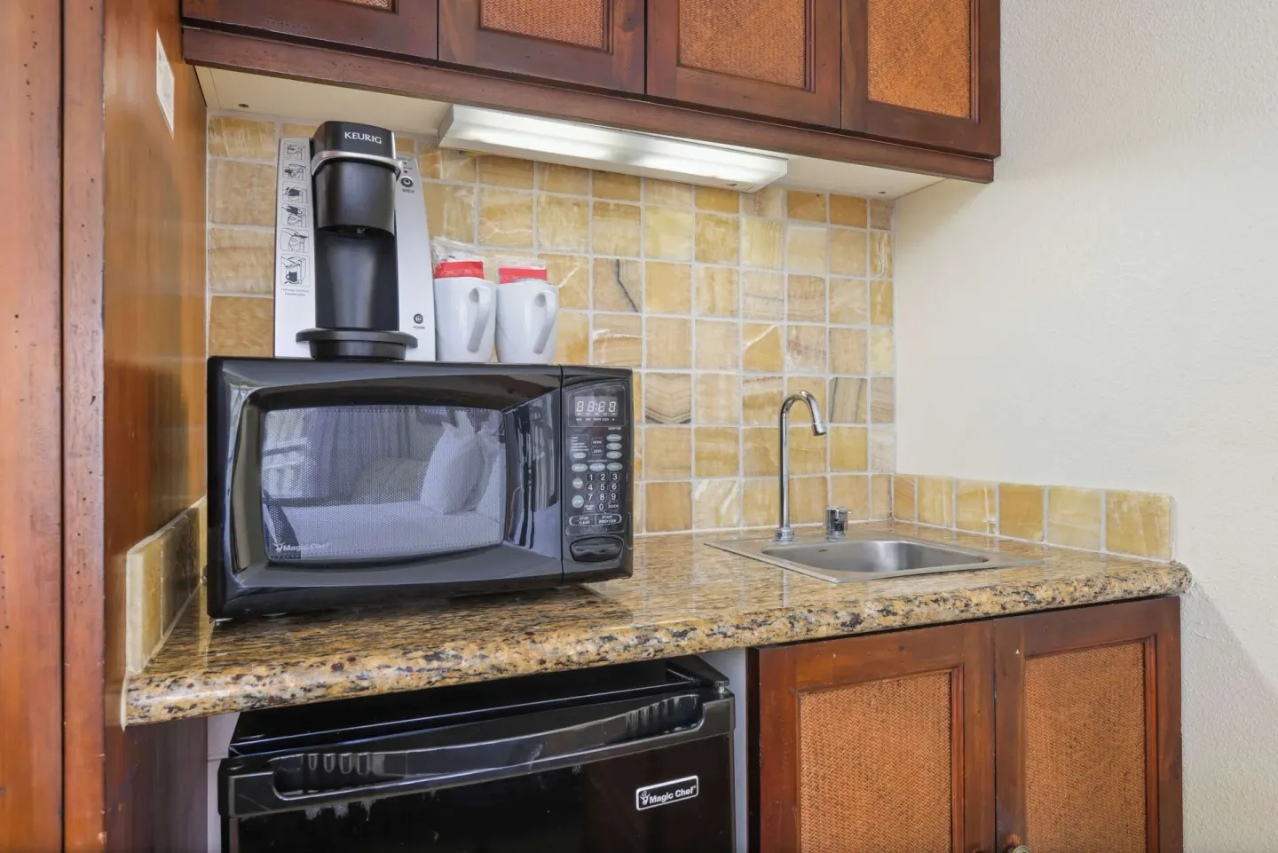Ocean View room kitchenette with microwave, coffee maker, mini-fridge, and sink at Aston Islander on the Beach.