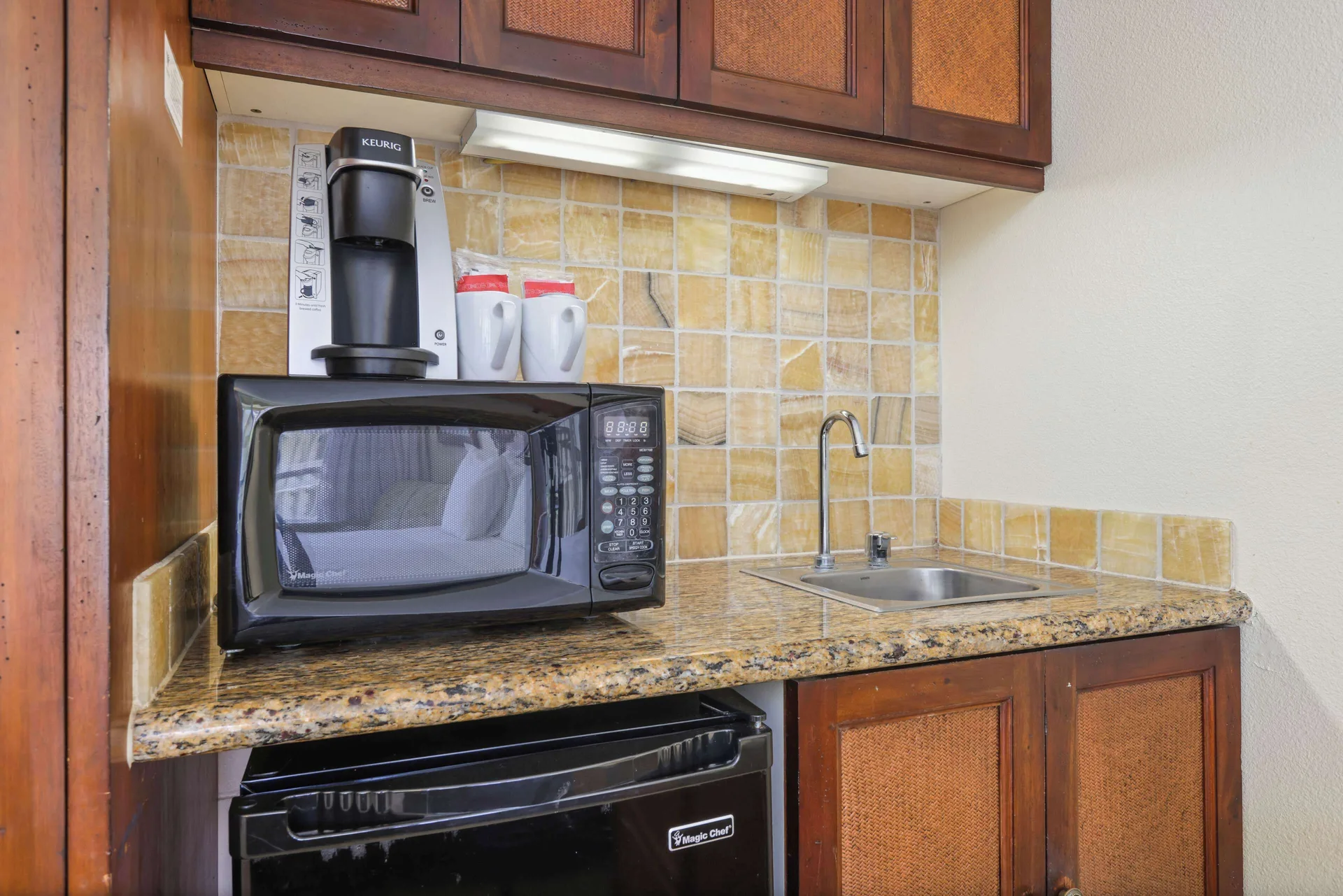Ocean View room kitchenette with microwave, coffee maker, mini-fridge, and sink at Aston Islander on the Beach.