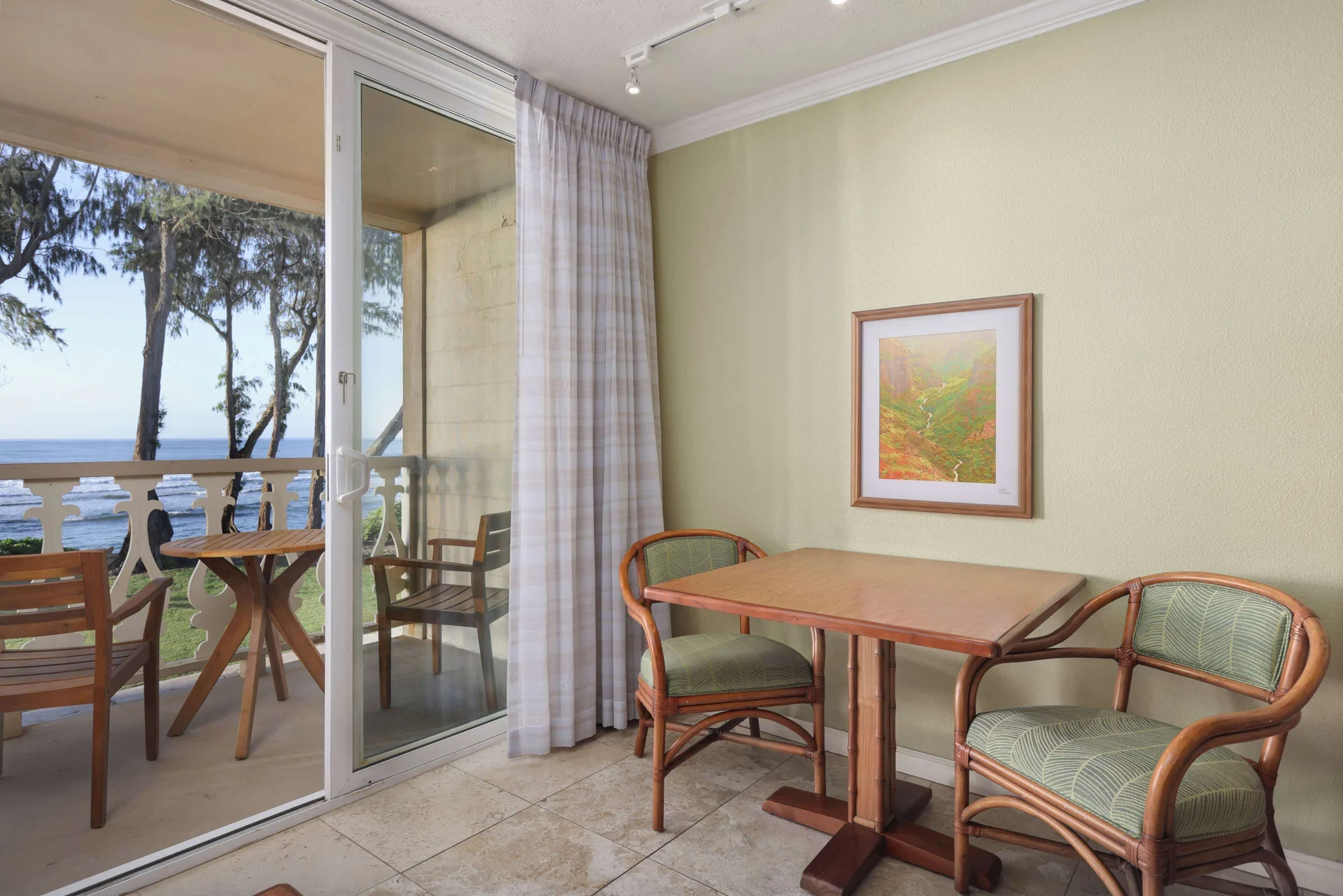 Oceanfront room dining table beside balcony doors at Aston Islander on the Beach.