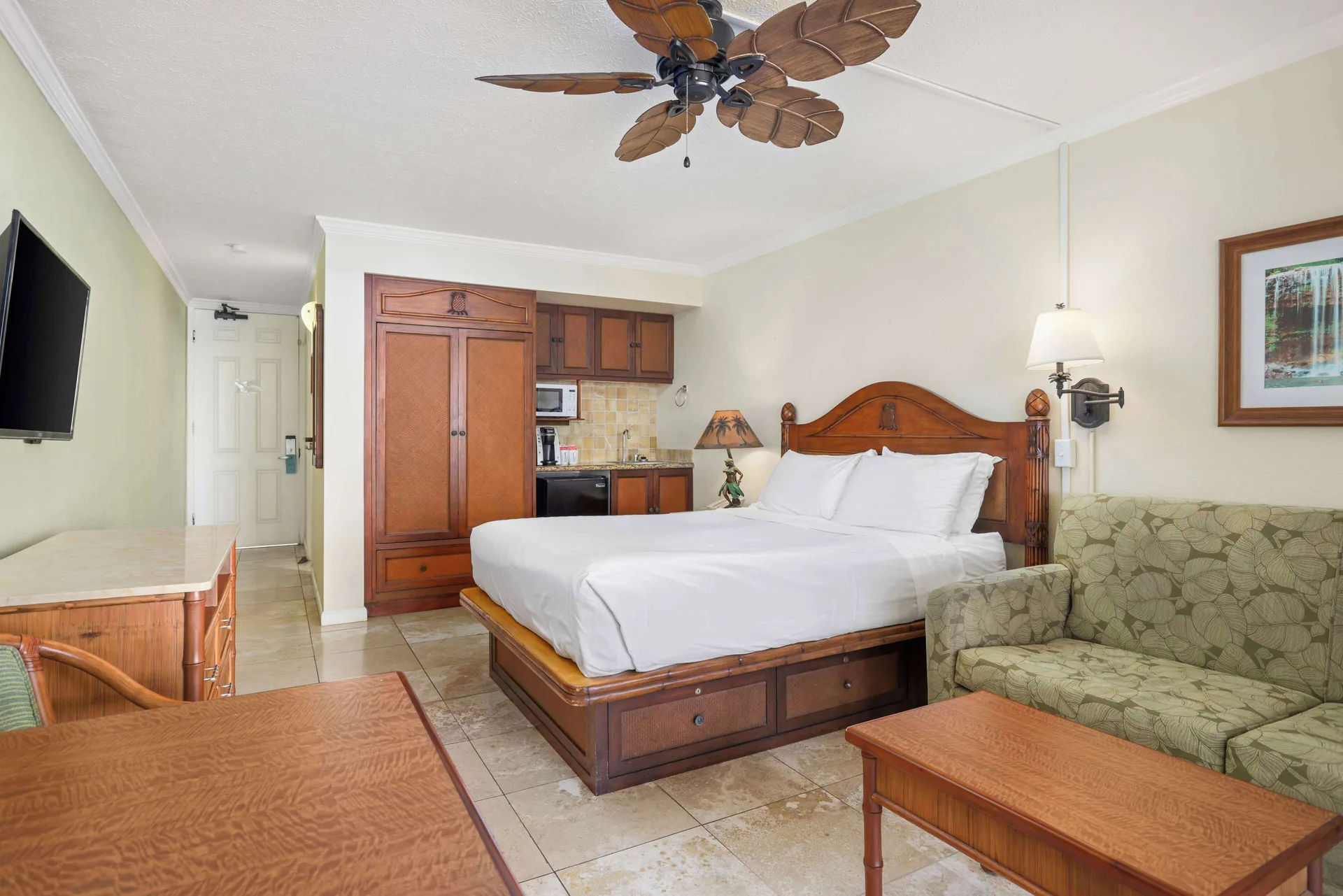 Oceanfront room with king bed, sofa, kitchenette, dresser, and TV at Aston Islander on the Beach.