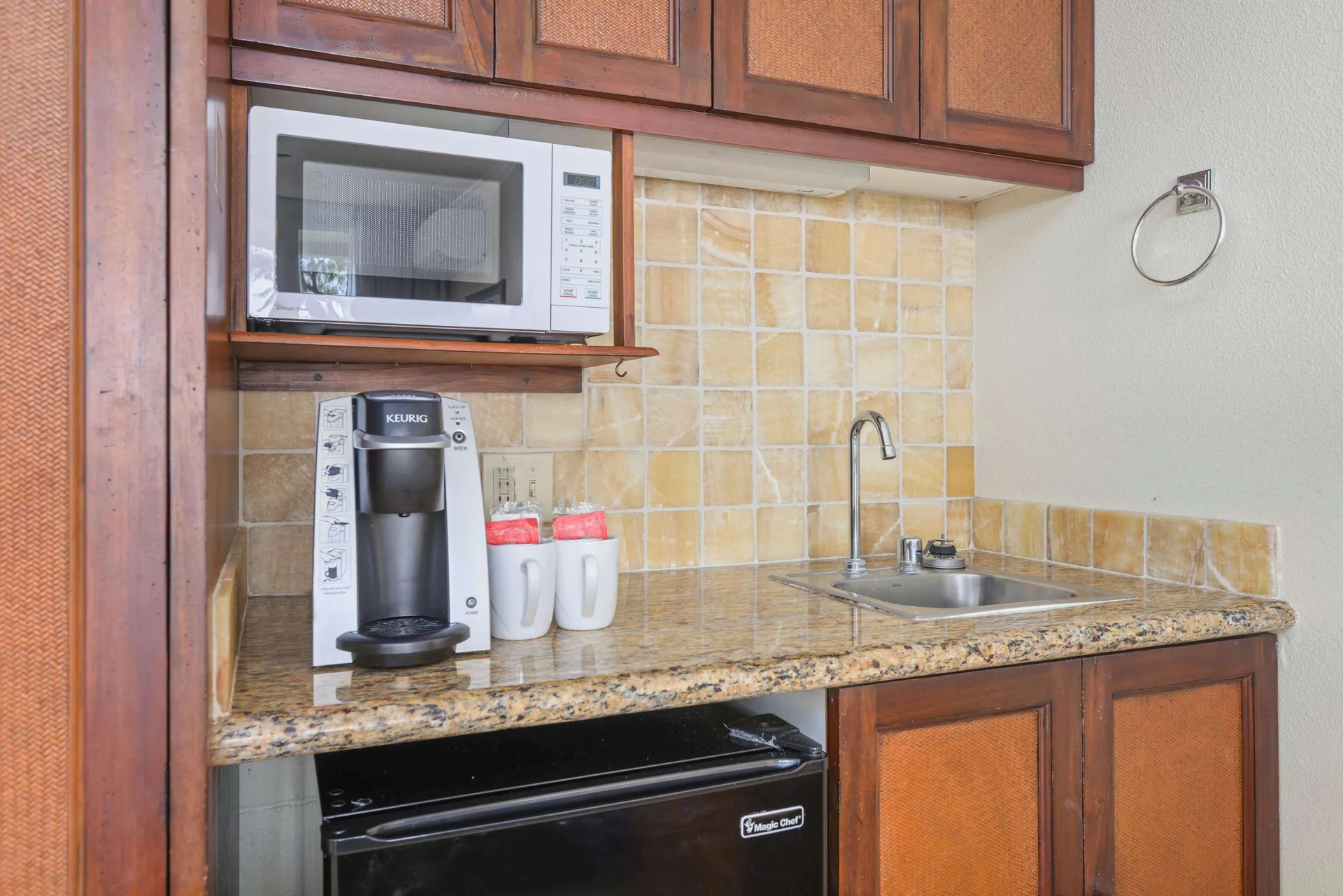 Oceanfront room kitchenette with microwave, coffee maker, mini-fridge, and sink at Aston Islander on the Beach.
