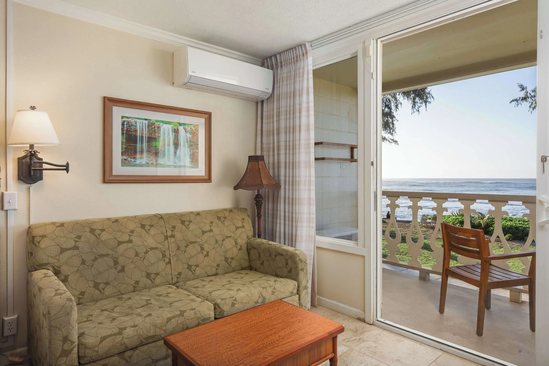 Oceanfront room sofa beside sliding balcony doors at Aston Islander on the Beach.