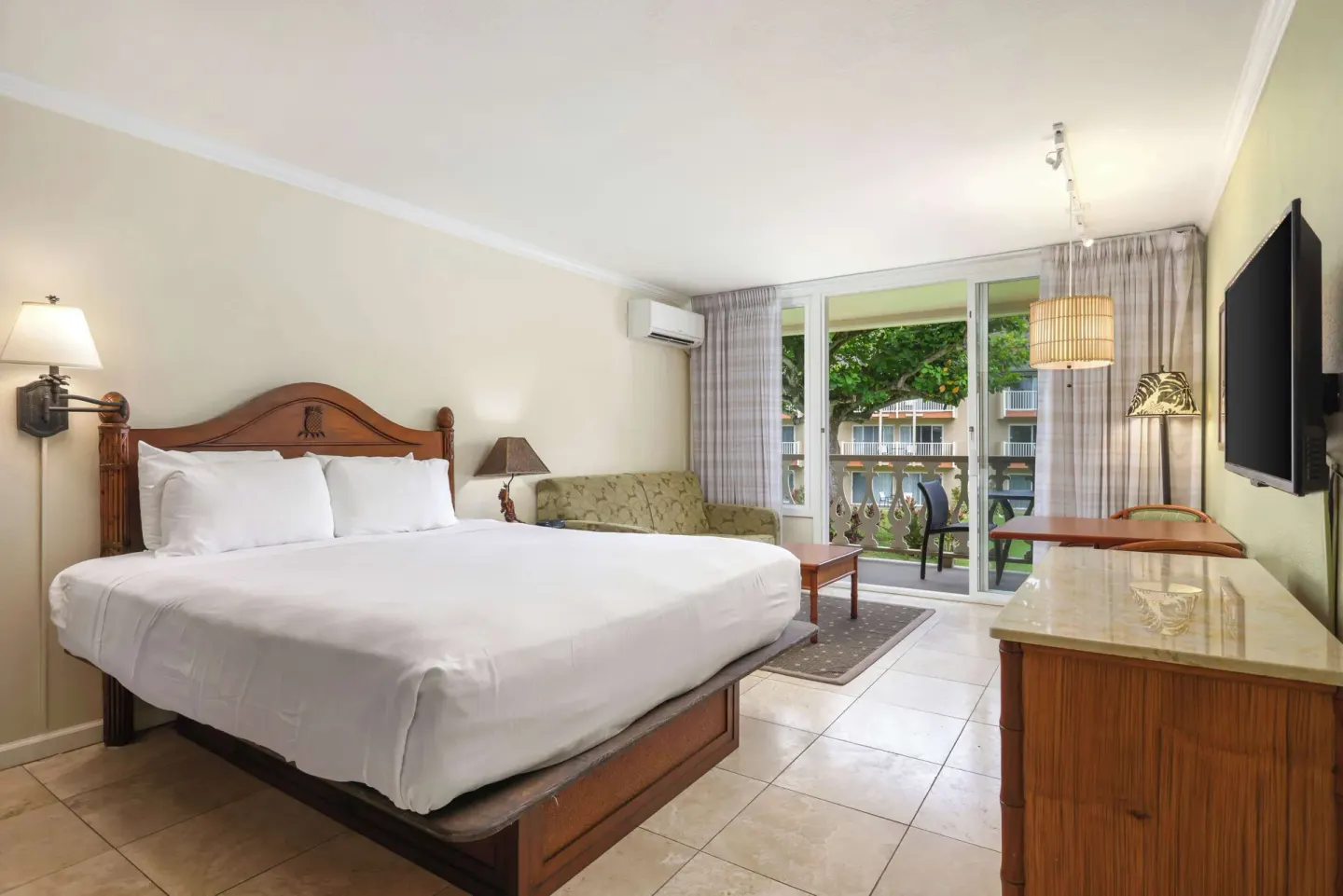 Partial ocean view room with king bed and balcony at Aston Islander on the Beach.
