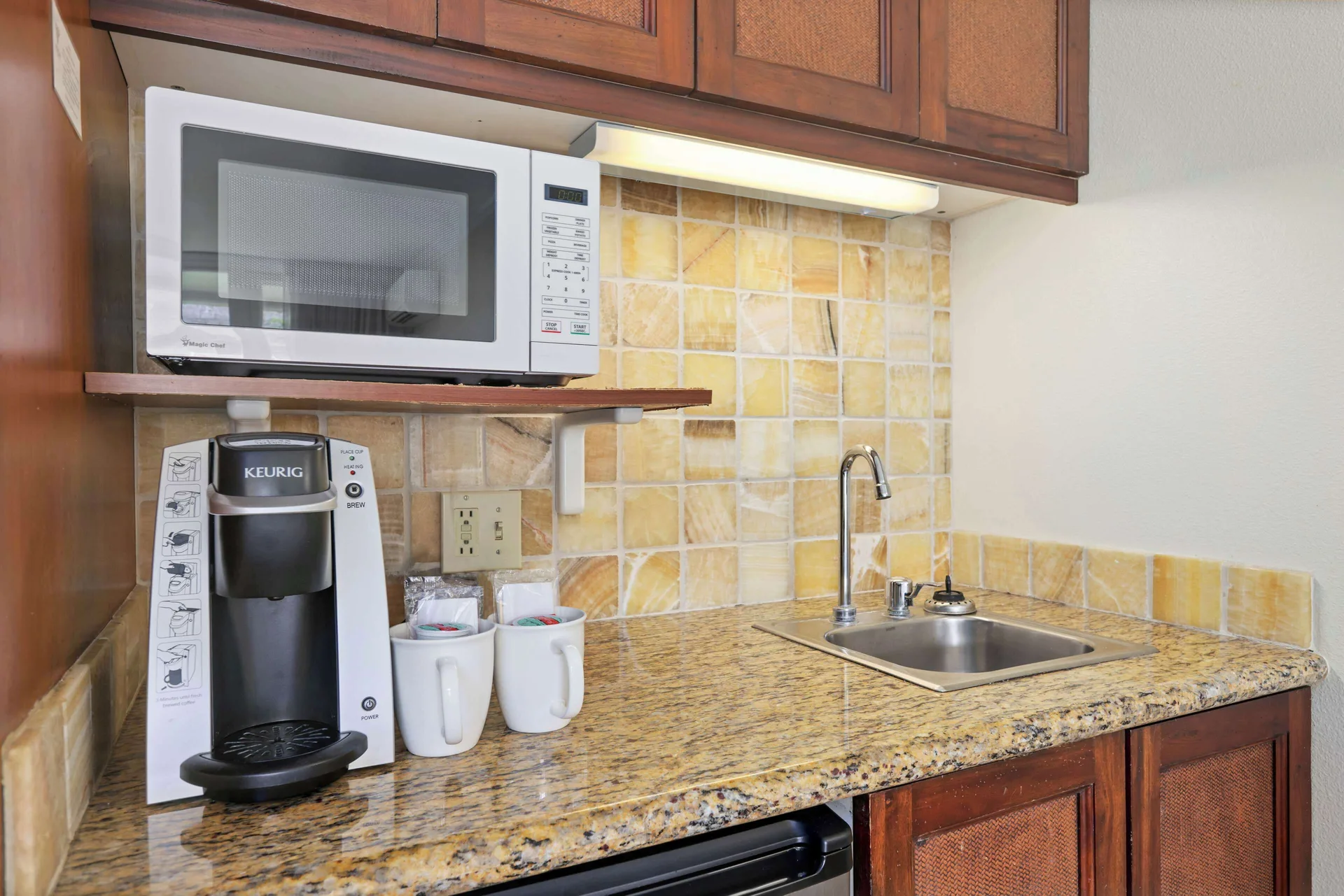 Kitchenette with microwave, coffee maker, sink, and cabinets at Aston Islander on the Beach.