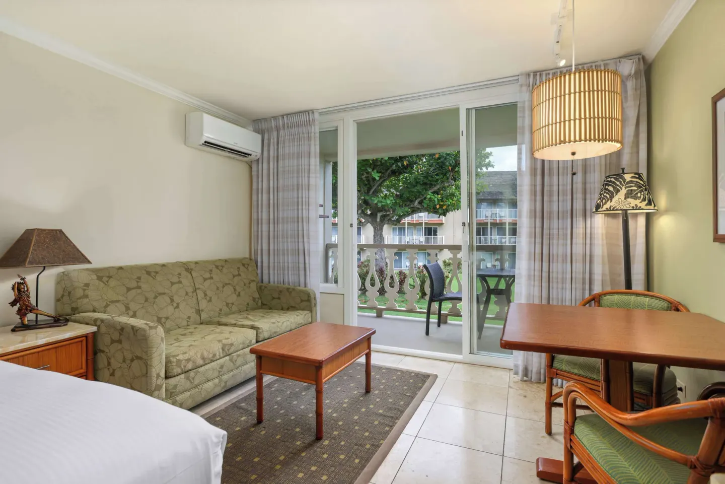 Sitting area with sofa, table, and balcony doors at Aston Islander on the Beach.