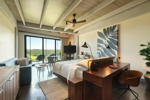 King bed guest room with desk and balcony view at Atelier Playa Mujeres.