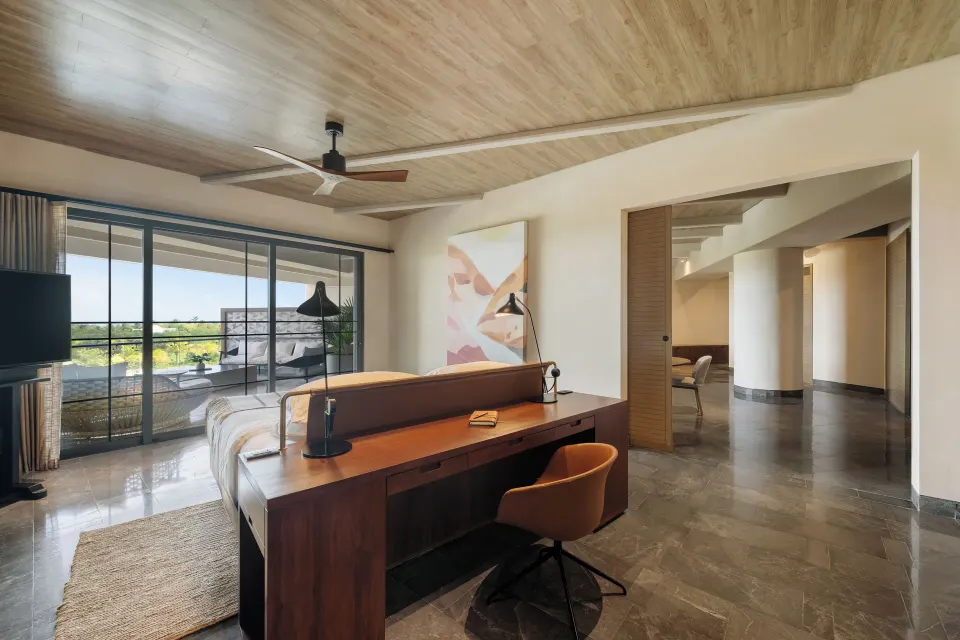 Inspira Business Suite bedroom and desk area at Atelier Playa Mujeres with balcony doors.