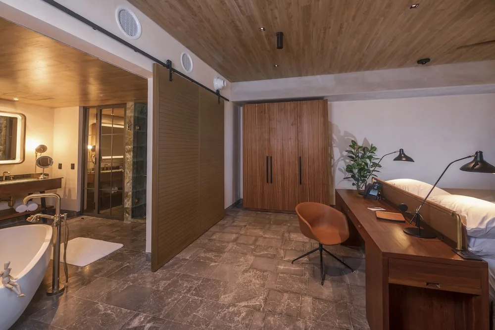 Inspira Business Suite with bed, desk, wardrobe and open bathroom at Atelier Playa Mujeres.
