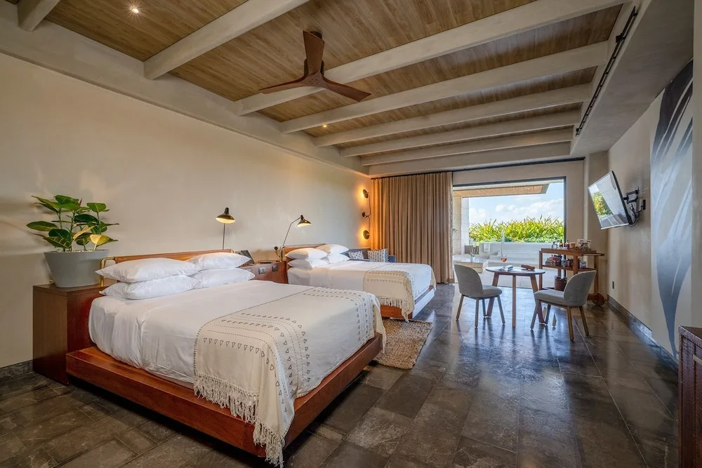 Inspira Corner Suite with two beds and terrace access at Atelier Playa Mujeres.