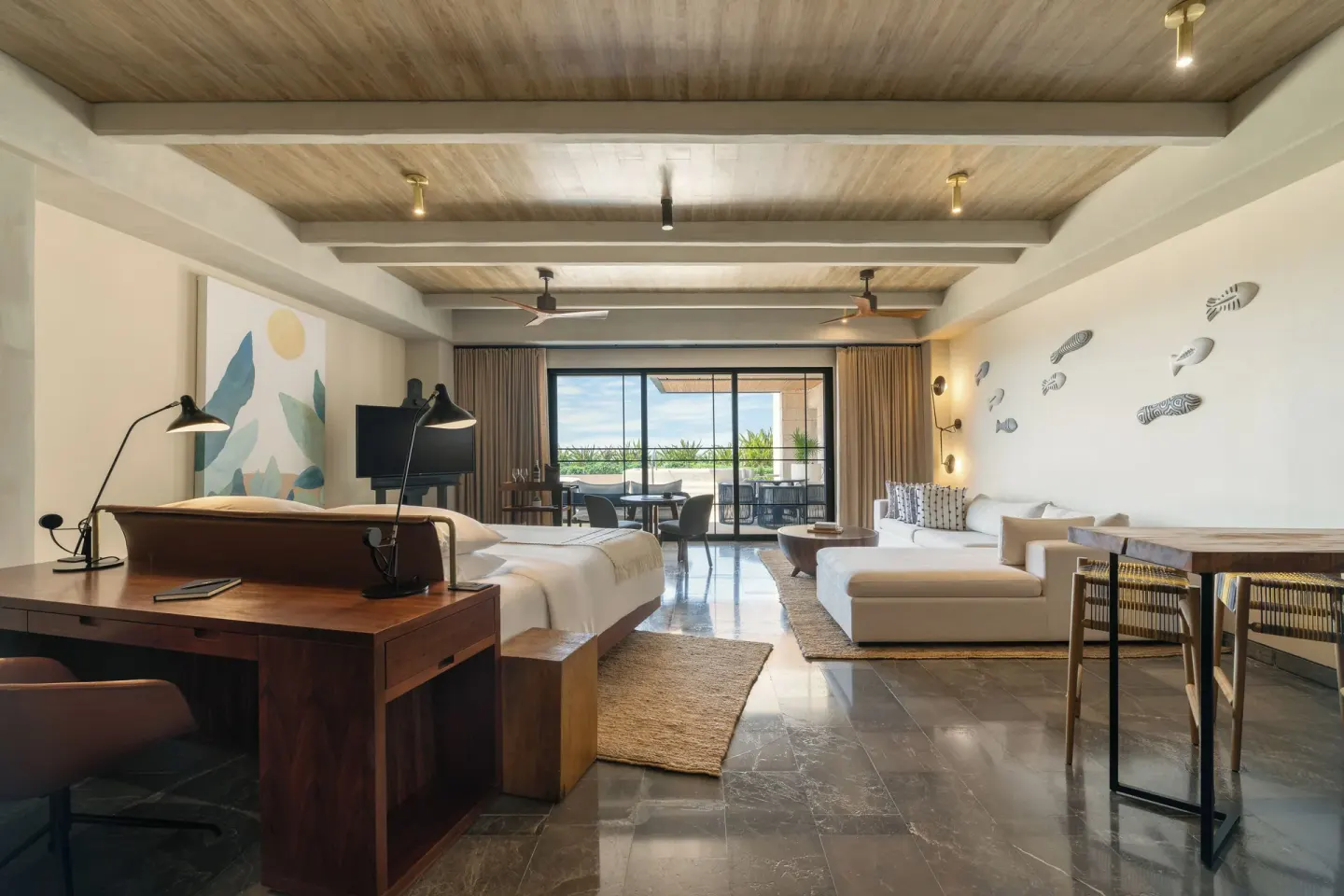 Inspira Corner Suite king bed, work desk and sofa lounge at Atelier Playa Mujeres.