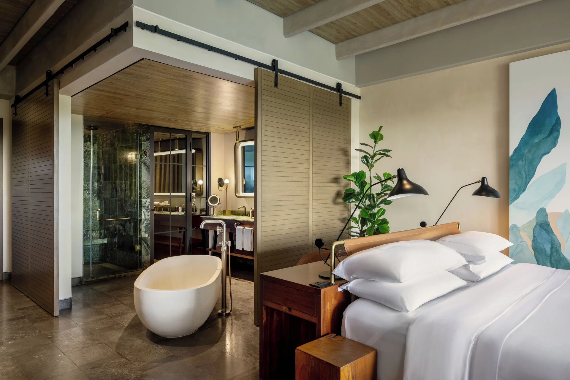 Inspira Junior Suite Ocean Front bed beside open bath area at Atelier Playa Mujeres.