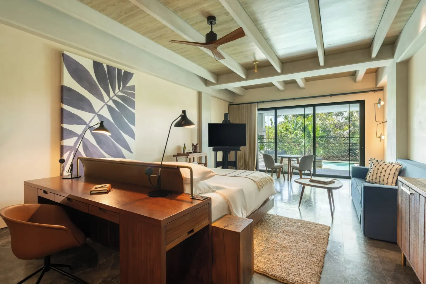 Inspira Junior Suite Swim Out room with bed, desk, sofa and terrace at Atelier Playa Mujeres.