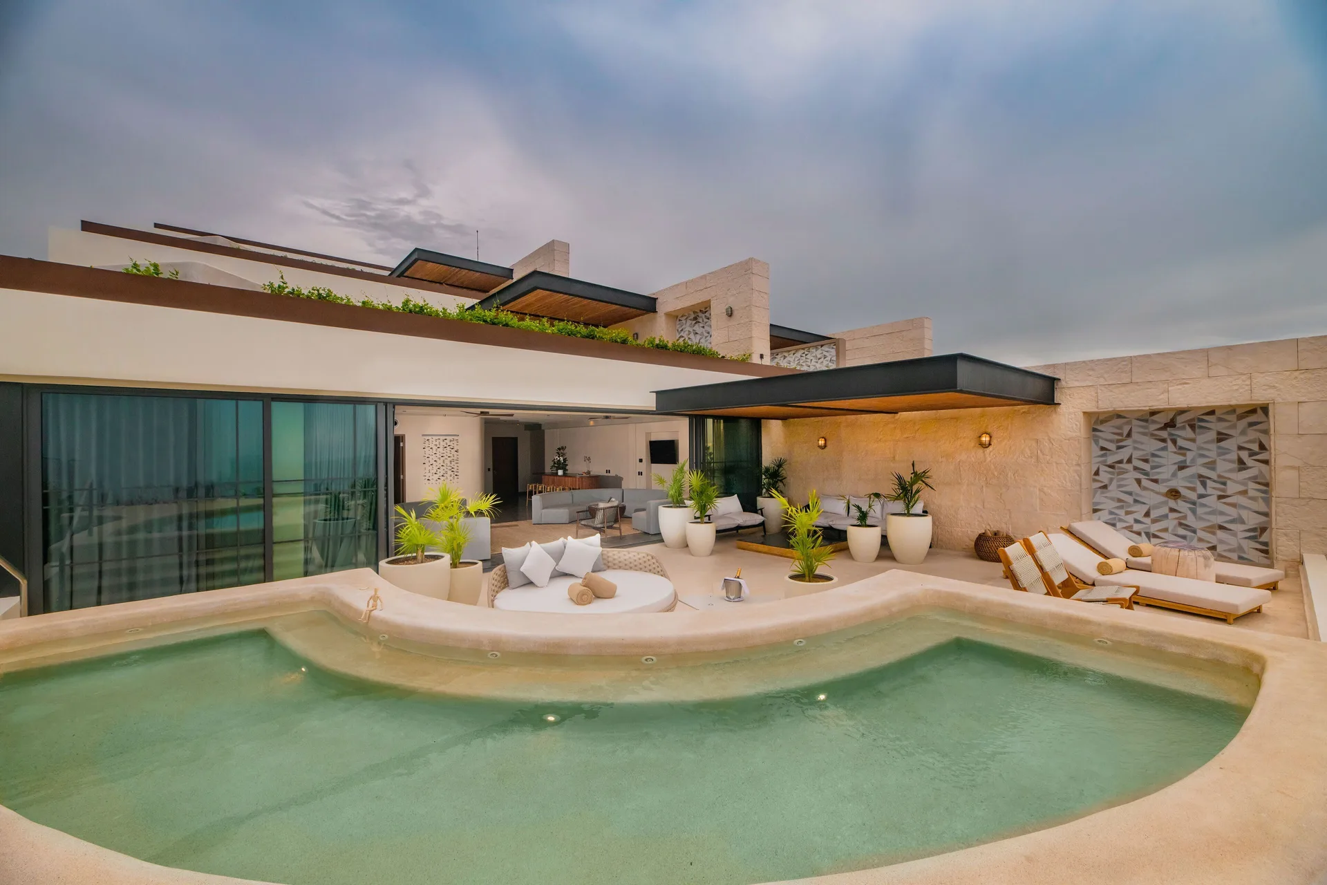 Inspira Master Suite Ocean Front terrace pool at dusk at Atelier Playa Mujeres.
