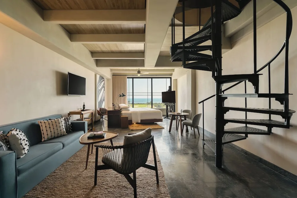Inspira Rooftop Suite with lounge, spiral stair and king bed at Atelier Playa Mujeres.