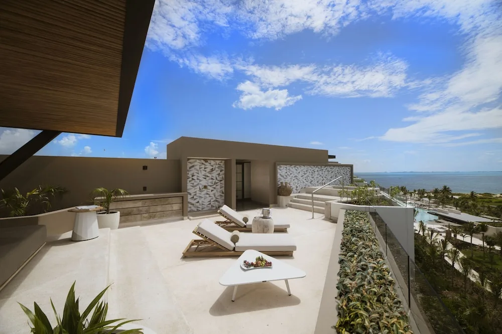 Inspira Rooftop Suite terrace with loungers and ocean view at Atelier Playa Mujeres.