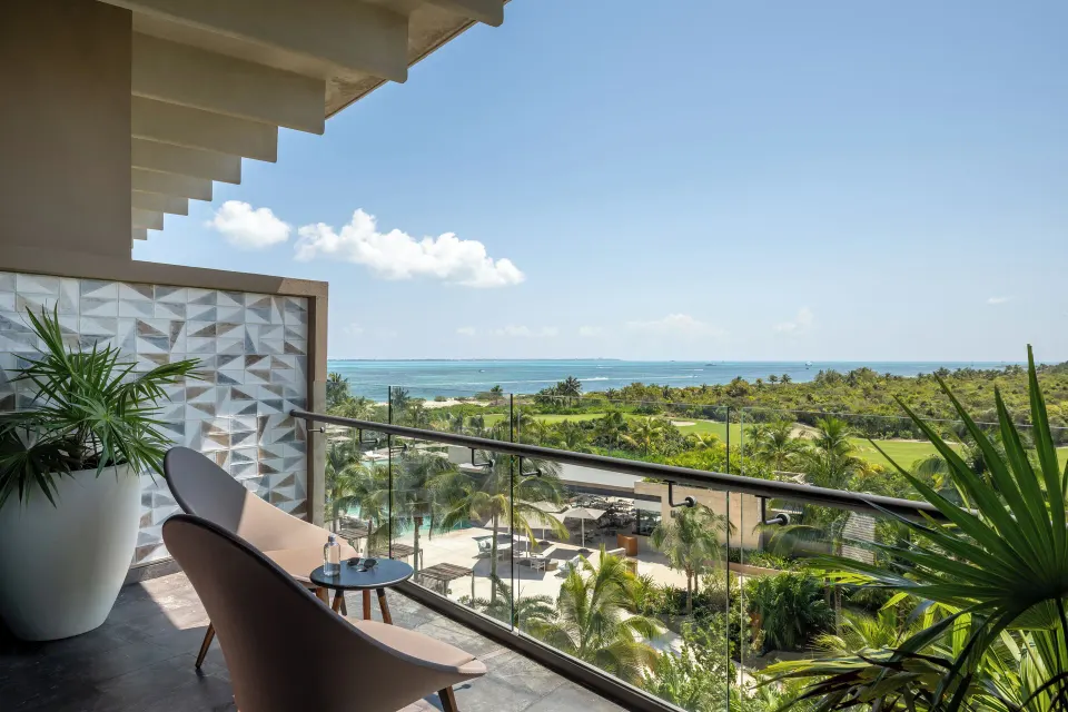 Junior Suite Ocean View balcony with chairs and sea view at Atelier Playa Mujeres.