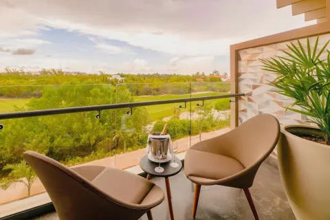 Junior Suite balcony with two chairs and green view at Atelier Playa Mujeres.