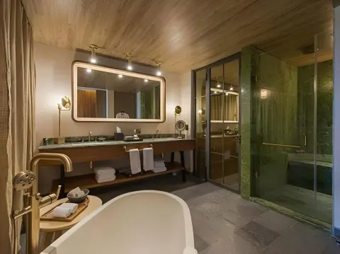 Junior Suite bathroom with freestanding tub and double vanity at Atelier Playa Mujeres.