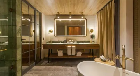 Junior Suite bathroom with tub and double vanity at Atelier Playa Mujeres.