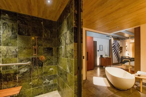 Junior Suite bathroom with shower and freestanding tub at Atelier Playa Mujeres.