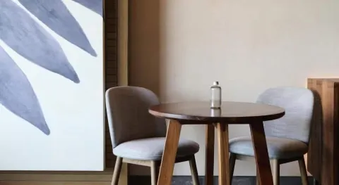 Junior Suite dining table with two upholstered chairs at Atelier Playa Mujeres.