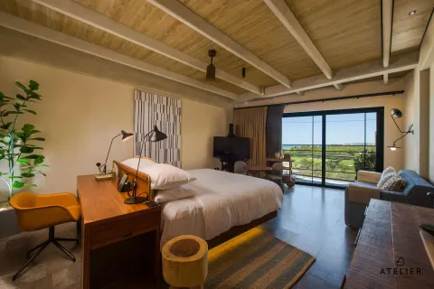 Junior Suite king bed and balcony view at Atelier Playa Mujeres.