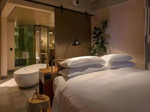 Junior Suite king bed and freestanding tub at Atelier Playa Mujeres.