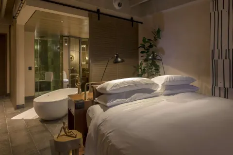 Junior Suite king bed with freestanding tub at Atelier Playa Mujeres.