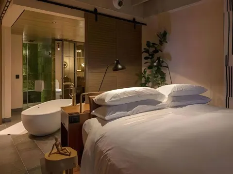 Junior Suite king bed with freestanding tub at Atelier Playa Mujeres.
