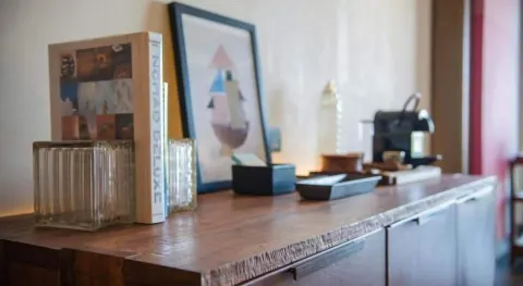 Junior Suite minibar counter with glasses, artwork, and coffee machine at Atelier Playa Mujeres.