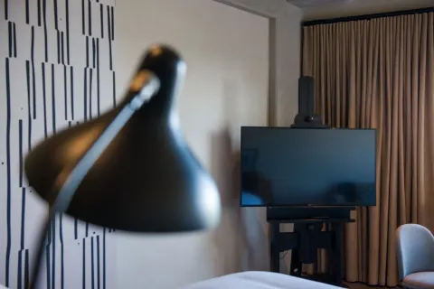 Junior Suite TV and wall lamp detail at Atelier Playa Mujeres.