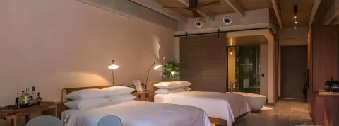 Junior Suite with two beds and open bathroom area at Atelier Playa Mujeres.