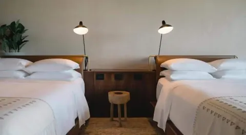 Two Junior Suite beds with reading lamps at Atelier Playa Mujeres.