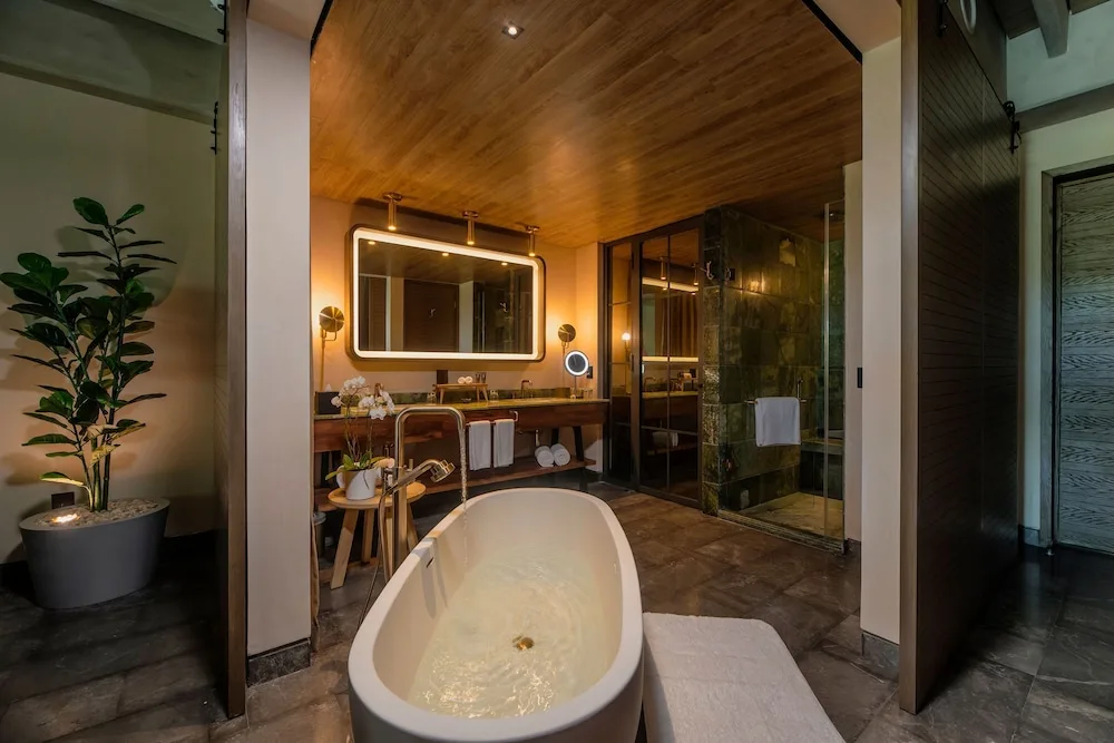 Freestanding tub, vanity, and shower in a Wheelchair Accessible Junior Suite at Atelier Playa Mujeres.