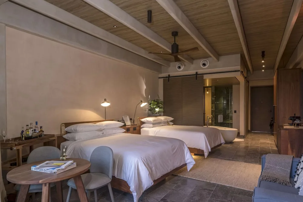 Accessible junior suite with two beds and open bath area at Atelier Playa Mujeres.