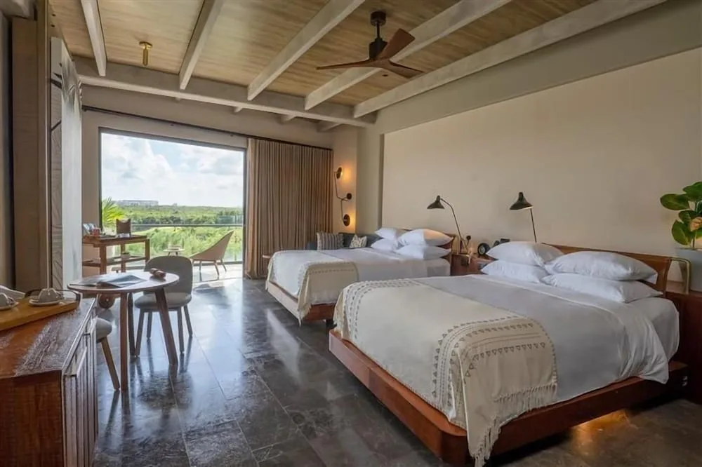 Two beds and balcony view in a Wheelchair Accessible Junior Suite at Atelier Playa Mujeres.